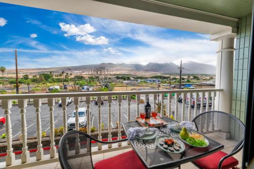 Lahaina Shores Beach Resort 206 في Wainee: شرفة مع طاولة وكراسي وإطلالة على المدينة