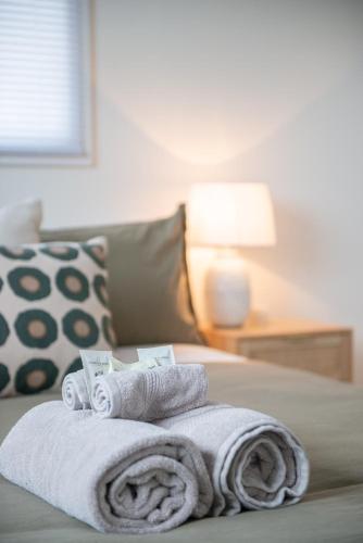 a pile of towels on top of a bed at Spacious 3-bedroom Home In Roslyn With Views in Dunedin
