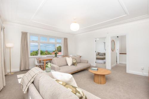 a living room with a couch and a table at Spacious 3-bedroom Home In Roslyn With Views in Dunedin