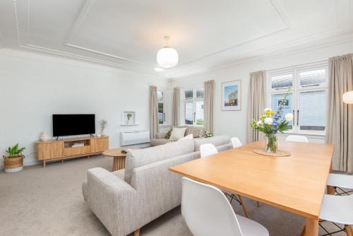 a living room with a couch and a table at Spacious 3-bedroom Home In Roslyn With Views in Dunedin