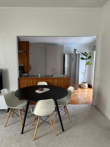 a kitchen with a table and chairs in a room at Urban Kingsland Bungalow in Auckland