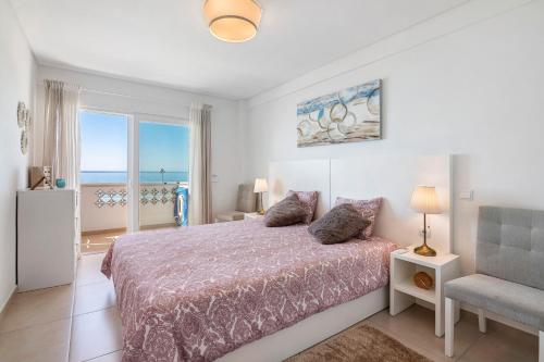 a bedroom with a bed with a view of the ocean at Paraná in Quarteira