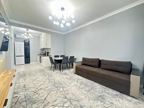 a living room with a couch and a table at Двухкомнатная квартира с евроремонтом в центре Алматы, рядом с ТРЦ MEGA Center in Almaty