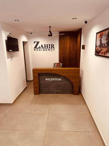 a waiting room with a sign on the wall at ZAHIR RESIDENCY calicut in Kozhikode