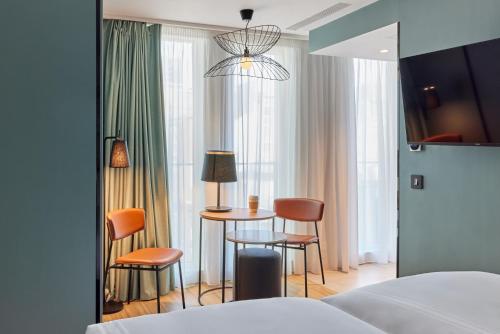 a hotel room with a bed and a table and chairs at Aparthotel Adagio London City East in London