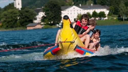 a group of children riding on a boat with a parrot on the water at Ferienhaus Silja in Steindorf am Ossiacher See