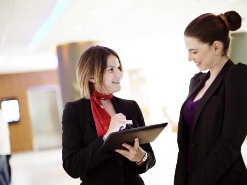 two women standing next to each other holding a tablet at Novotel London Waterloo in London