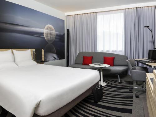 a hotel room with a bed and a couch at Novotel London Waterloo in London