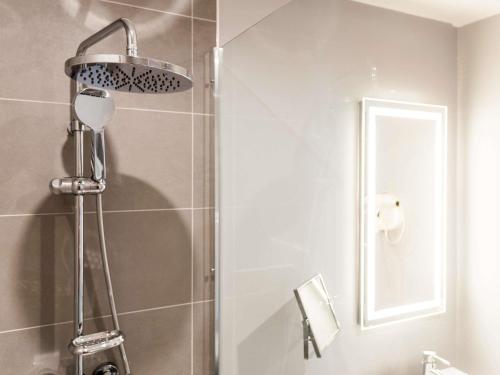 a shower with a shower head in a bathroom at Novotel Firenze Nord Aeroporto in Sesto Fiorentino