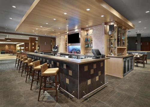 a bar with a row of stools in a restaurant at DoubleTree by Hilton Hotel & Conference Centre Regina in Regina