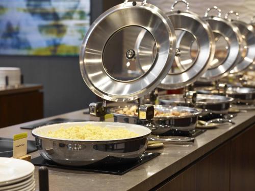 a row of pans of food on a buffet at DoubleTree by Hilton Hotel & Conference Centre Regina in Regina