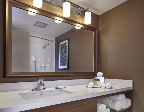 a bathroom with a sink and a large mirror at DoubleTree by Hilton Hotel & Conference Centre Regina in Regina