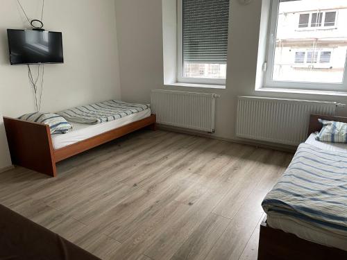 a bedroom with two beds and two windows at Monteur-Apartment am Bahnhof in Muhlheim am Main