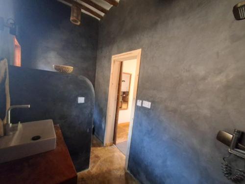 a bathroom with a sink and a door to a hallway at Zanzi-Barbar-Home in Jambiani