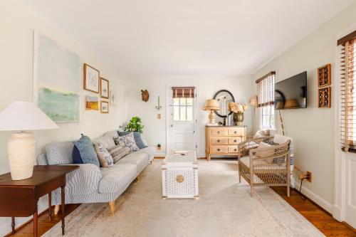 un soggiorno con un divano e un tavolo di Cottage on King Charming Historic Leesburg Home a Leesburg