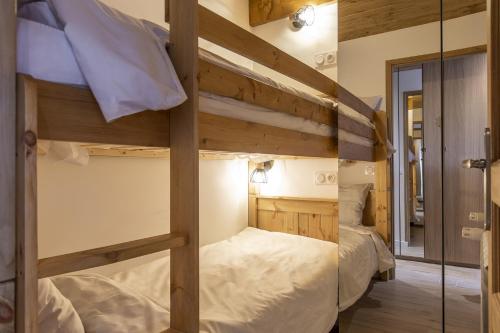 two bunk beds in a room with a mirror at Résidence La Forêt Du Praz - Courchevel 1850 in Courchevel