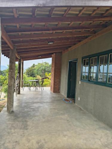 a patio with a table and chairs on it at Montanha Home in Monte Verde