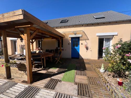 a wooden patio with a table and a wooden pergola at L'étape Giennoise in Gien