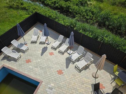 a group of chairs and umbrellas next to a pool at Prenociste jezerske zvezde in Veliko Gradište