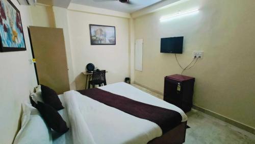 a hotel room with a bed and a tv at CR Residency - Near Us Embassy Chanakyapuri in New Delhi