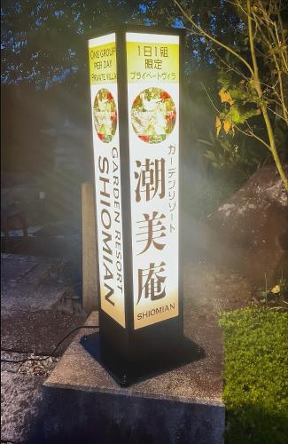 a sign for a restaurant with a sign in at ガーデンリゾート 潮美庵 in Hatsukaichi