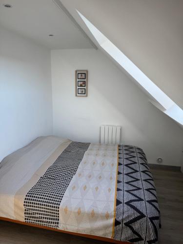 a bedroom with a bed in a white room at Charmante maison avec terrasse in Saint-Omer-Capelle
