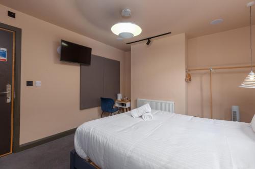 a bedroom with a white bed and a flat screen tv at ART B&B in Blackpool