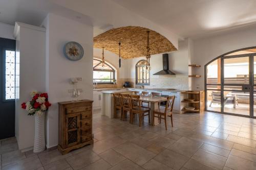 a large kitchen with a table and chairs in it at The Stone Villa Luxury Nature Retreat Galilee in Hosha‘ya