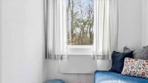 a room with a window and a blue couch at 10041-1-Rorvig-Langesovej-2 in Rørvig