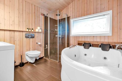 a bathroom with a white tub and a toilet at 14233-Grevinge-Grevinge-Kanalvej-95 in Grevinge