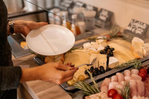 a woman is preparing food at a buffet at Weinhotel Wasem in Ingelheim am Rhein