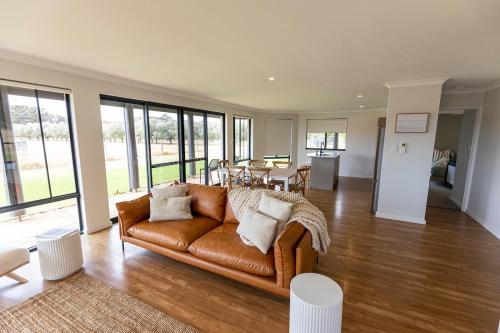 a living room with a brown couch and a table at Birak Cottage at Windance in Yallingup