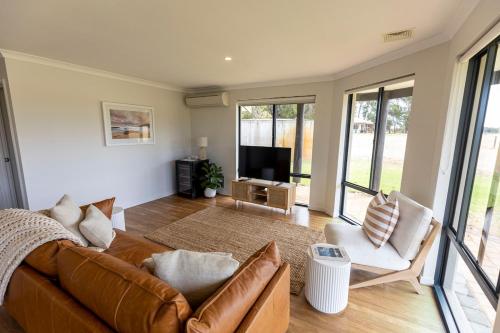 a living room with a couch and a television at Birak Cottage at Windance in Yallingup