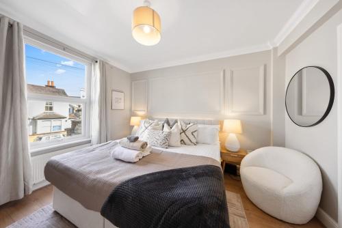 ein Schlafzimmer mit einem Bett, einem Stuhl und einem Fenster in der Unterkunft Long Stay Ready King Bed Kitchen WiFi Town in Gravesend