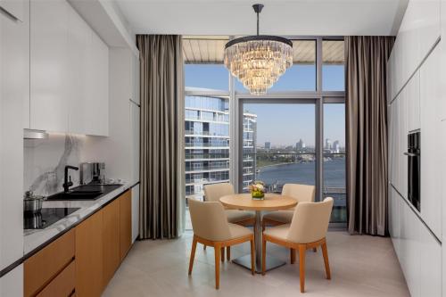 a kitchen with a table and chairs and a large window at Hilton Dubai Creek Hotel & Residences in Dubai