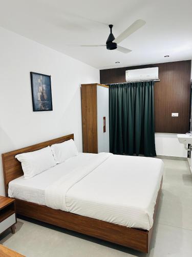 a bedroom with a large bed with a green curtain at ZAHIR RESIDENCY calicut in Kozhikode