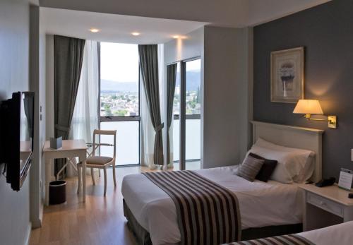 a hotel room with a bed and a large window at Amérian Catamarca in San Fernando del Valle de Catamarca
