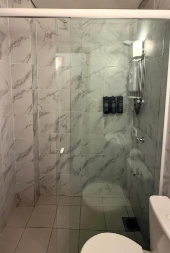 a bathroom with a glass shower with a toilet at Mandala Hotel in Encarnación
