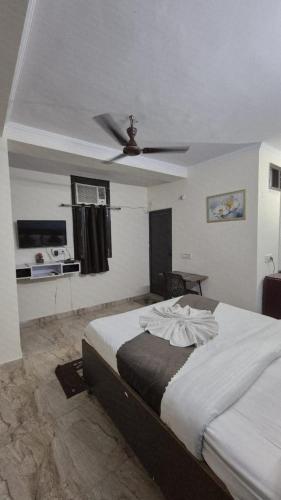 a bedroom with a bed with a ceiling fan at CR Residency - Near Us Embassy Chanakyapuri in New Delhi