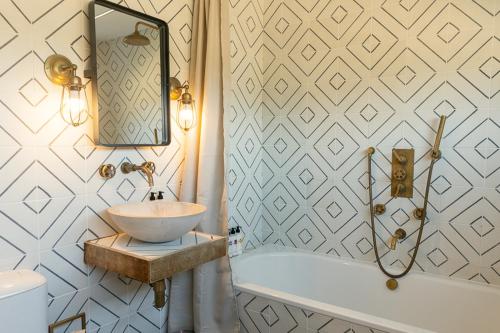 a bathroom with a sink and a tub at Fritton Lake Retreats in Fritton Norfolk