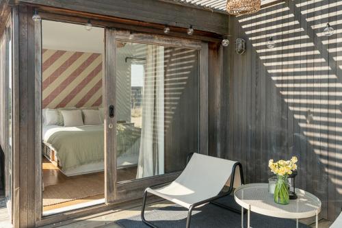 a patio with a bed and a chair and a table at Fritton Lake Retreats in Fritton Norfolk