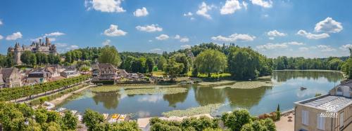 a view of a lake with a castle in the background at Logis Hotel Beaudon in Pierrefonds