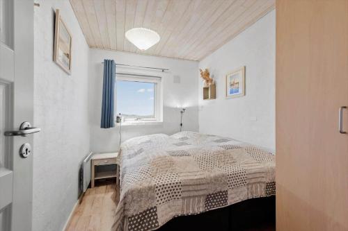 Un dormitorio blanco con una cama y una ventana. en FAN001-Fano-Skraeddermarken-52, en Fanø