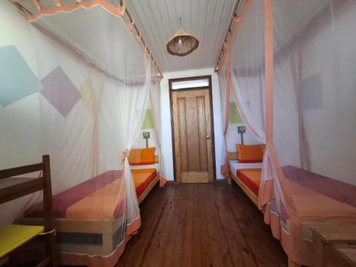 a room with two beds and a door at Gassy Country House Ivato Airport in Ivato