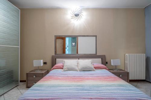 a bedroom with a bed with a mirror and two lamps at Lake Como 10 min - Terrace with Lake View - Wifi in Olginate