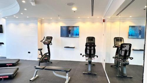 a gym with treadmills and elliptical machines at Grand Continental Hotel in Abu Dhabi