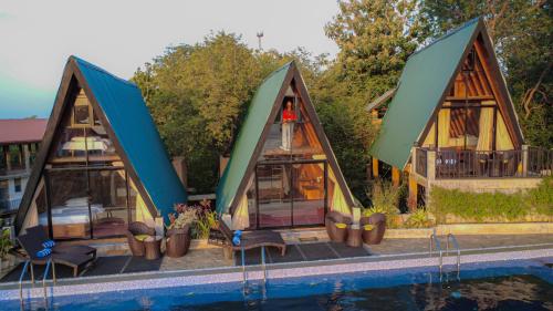 a house with glass doors and a swimming pool at Sundown Lake Hotel & Spa in Habarana
