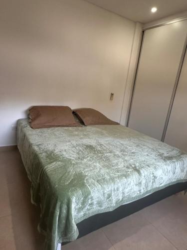 a bedroom with a bed with a green comforter at Departamento Soles in Posadas