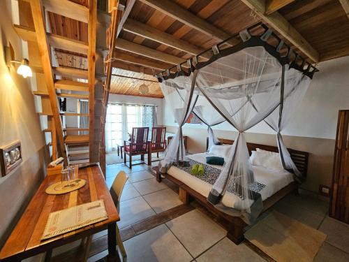 a bedroom with a bed with a mosquito net at Gassy Country House Ivato Airport in Ivato