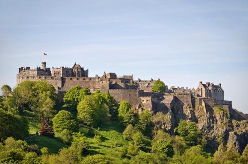 a castle perched on top of a mountain at Mount Royal Hotel Edinburgh by The Unlimited Collection in Edinburgh